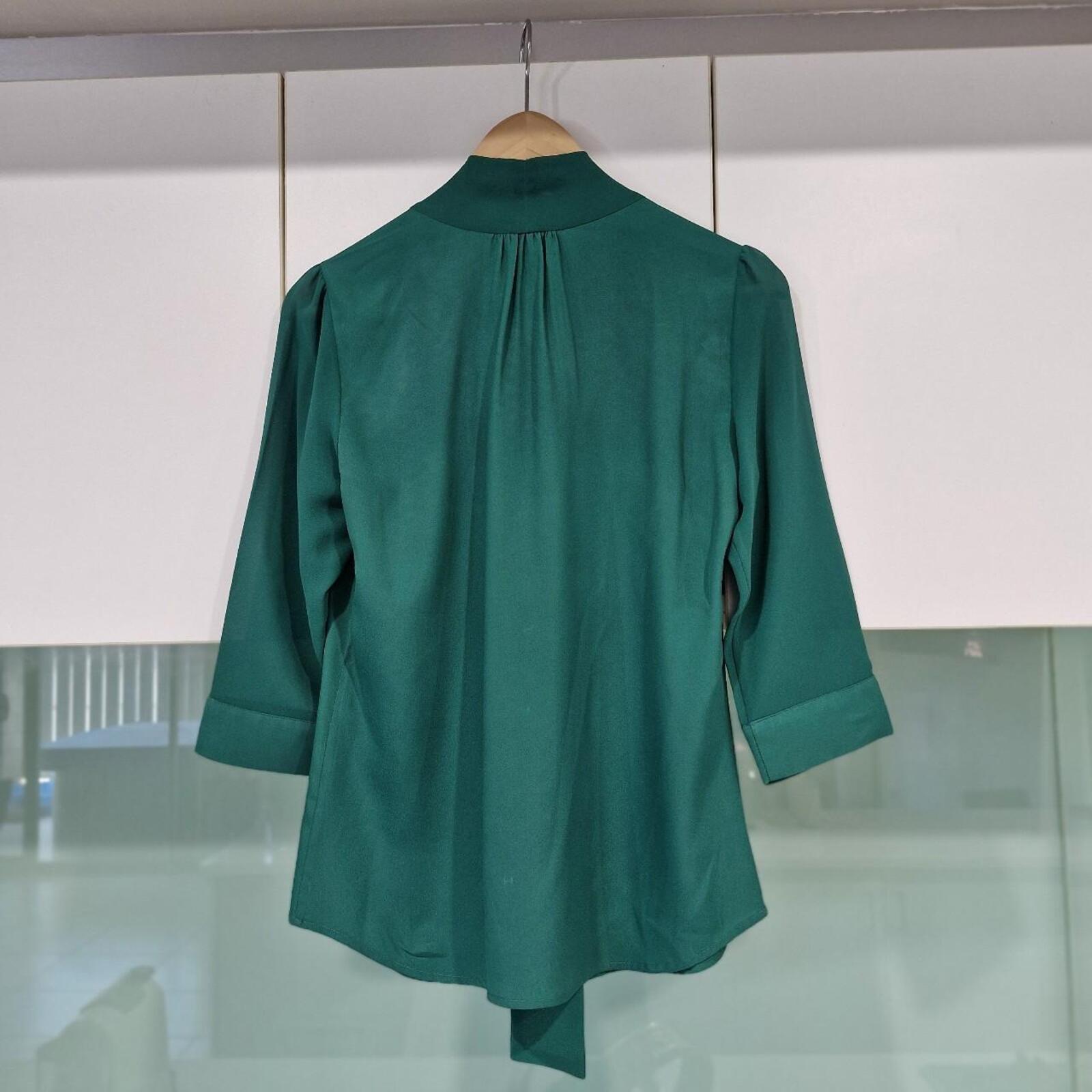 Basque green sheer blouse with tie detail.