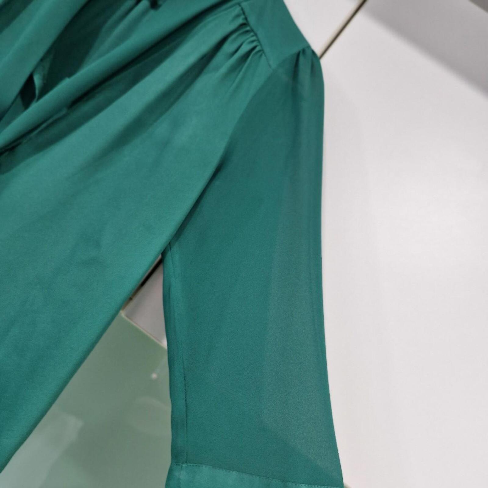 Basque green sheer blouse with tie detail.